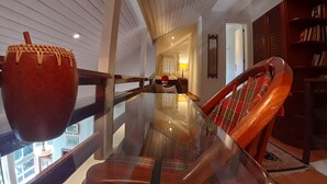 A modern interior with a glass table, wooden chairs, a bookshelf, and a large window. - Agradável Apartamento 2quartos Próximo ao Lago Negro a 4min do Centro (Gramado)