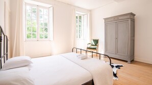 A bedroom with a bed, a chair, and a wardrobe. - The royal escape (Saint-Benoît-la-Forêt)