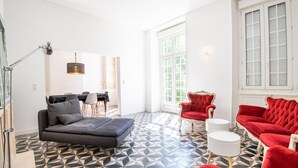 A spacious living area with a black sofa, red armchairs, and a dining table with chairs. - The royal escape (Saint-Benoît-la-Forêt)