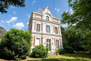 Un bâtiment à deux étages, doté d’une façade symétrique, de grandes fenêtres et d’une entrée centrale.