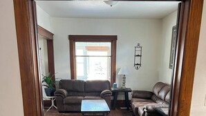 Ein Wohnzimmer mit braunem Ledersofa, einem Couchtisch und einem kleinen Beistelltisch mit Lampe.