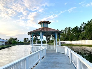 A gazebo with a metal roof and white railings on a wooden pier extending over water. - Poolside Escape in Orange Beach Near Beaches, Golf, The Wharf & Sportsplex (Orange Beach)