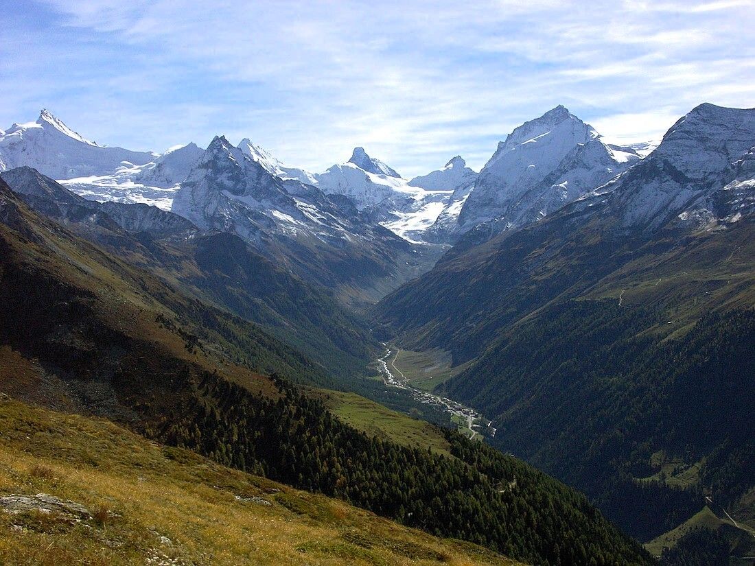 A mountainous landscape with snow-capped peaks and a valley.