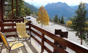 Ein Balkon mit Blick auf einen Parkplatz und Berge.