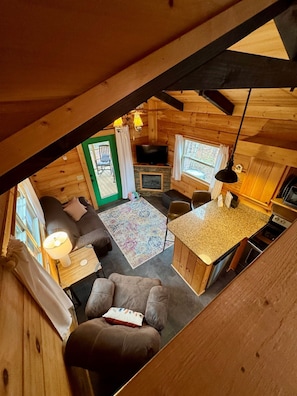 Un interno accogliente di una baita con zona living, angolo pranzo e cucina.