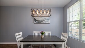 A dining area with a dark wooden table, white chairs, and a hanging light fixture. - ⭐️⭐️⭐️⭐️⭐️ Home next to KHP/Downtown (Lexington)