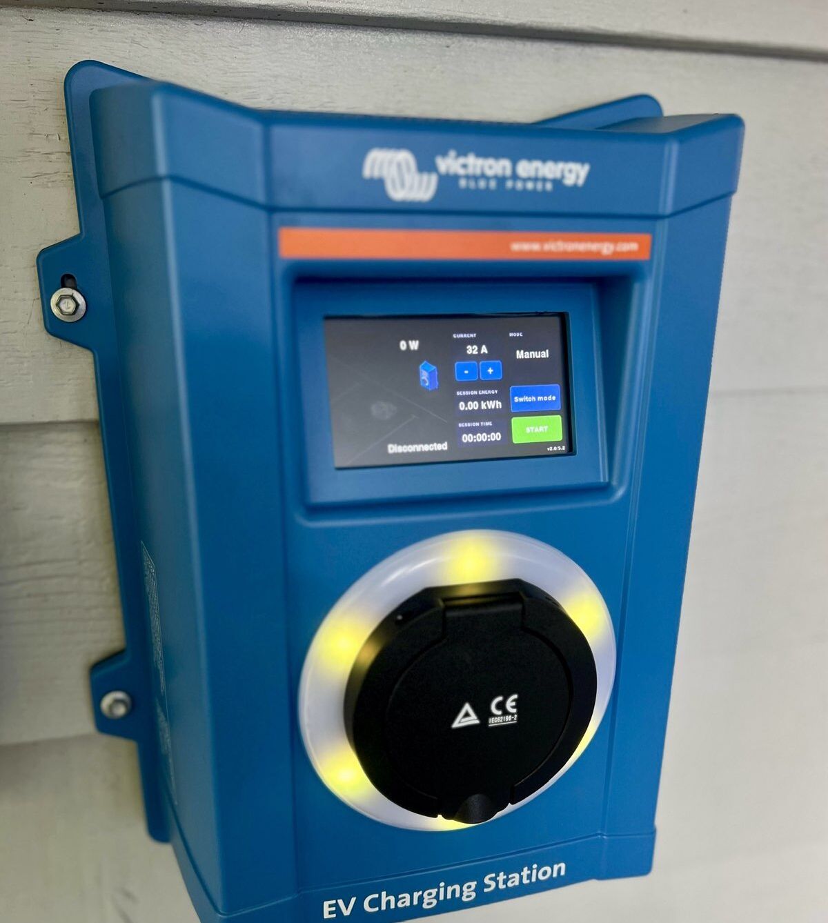 Une borne de recharge pour véhicules électriques dotée d’un écran numérique, d’une prise de recharge et du marquage de certification CE.