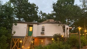 A two-story house with a green door, wooden staircase, and string lights. - Glamping Yurt + Luxury Bath at Serenity Ridge (Mill Spring)