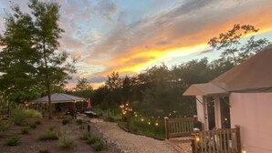A campsite with tents, a covered dining area, and a gravel path. - Glamping Yurt + Luxury Bath at Serenity Ridge (Mill Spring)