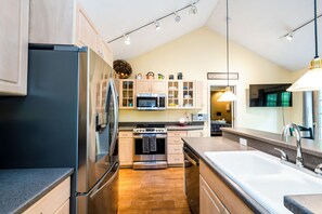 Enjoy cooking in this well-equipped kitchen with a central island, sink, and stove.