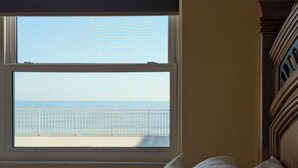 A bedroom with a view of the sea through a large window. - Beautiful direct ocean front beach access condo (Satellite Beach)
