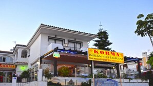 En bygning med et skilt for 'Korma Indian Restaurant' og en velkomstbanner.