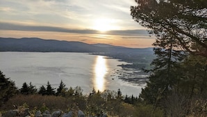 A stone wall with a view of a lake and mountains in the distance.