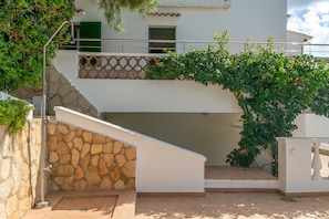A white building with a stone staircase leading to a balcony with green shutters. - CAN JAUME 10 - Villa very close to the sea, with private pool and free WiFi. (Mahón)