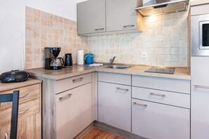 Una cucina compatta con una moka, un lavandino e pensili.