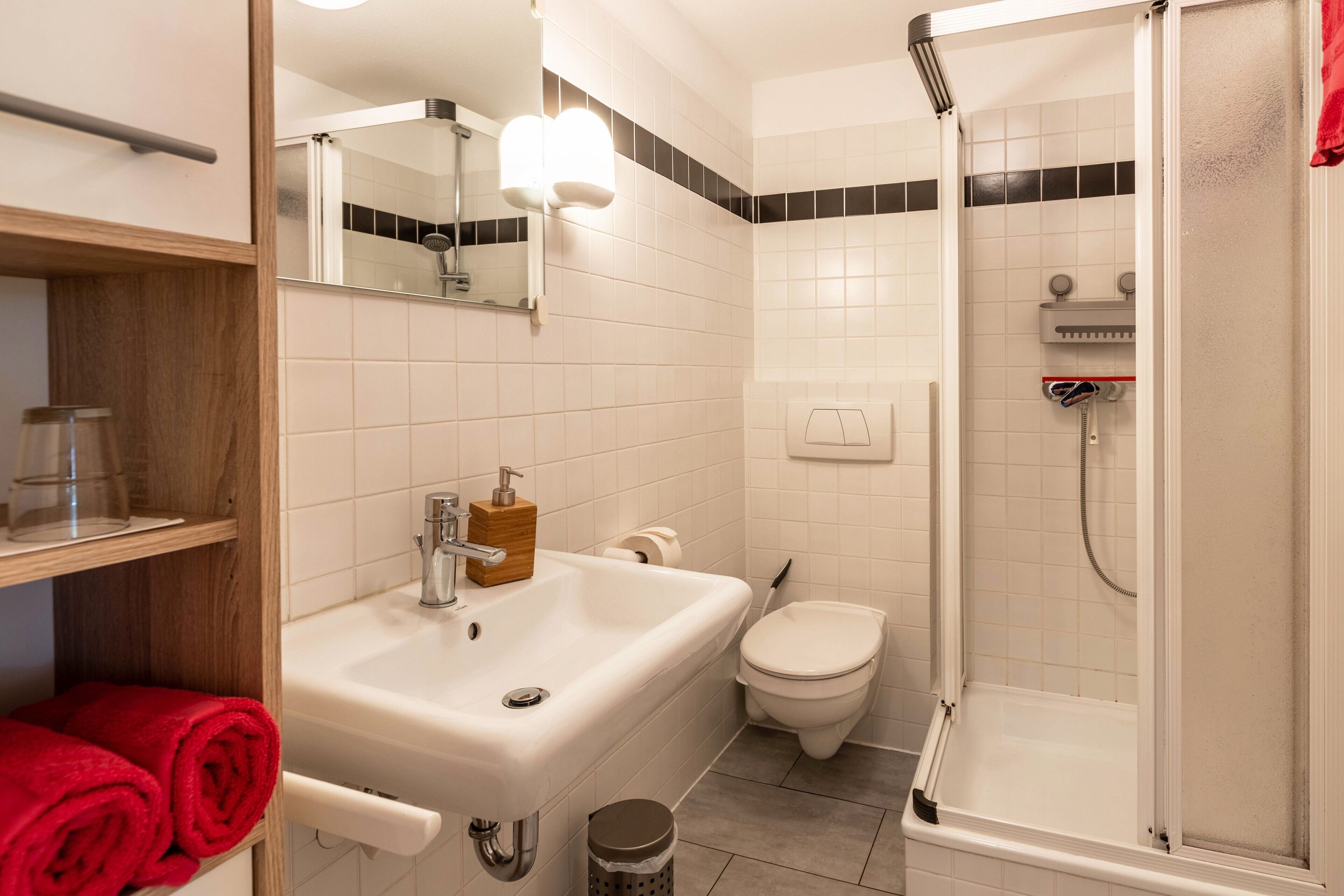 Un baño con lavamanos, inodoro y ducha.