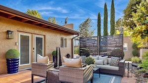 An outdoor patio with wicker furniture, a sofa, and a decorative fence. - New! Majestic VIEWS, HIKING, Modern Guest Suite (Sedona)