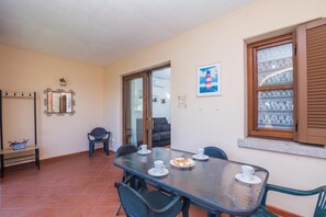 Uma sala de jantar com mesa de vidro, cadeiras e um prato de comida.