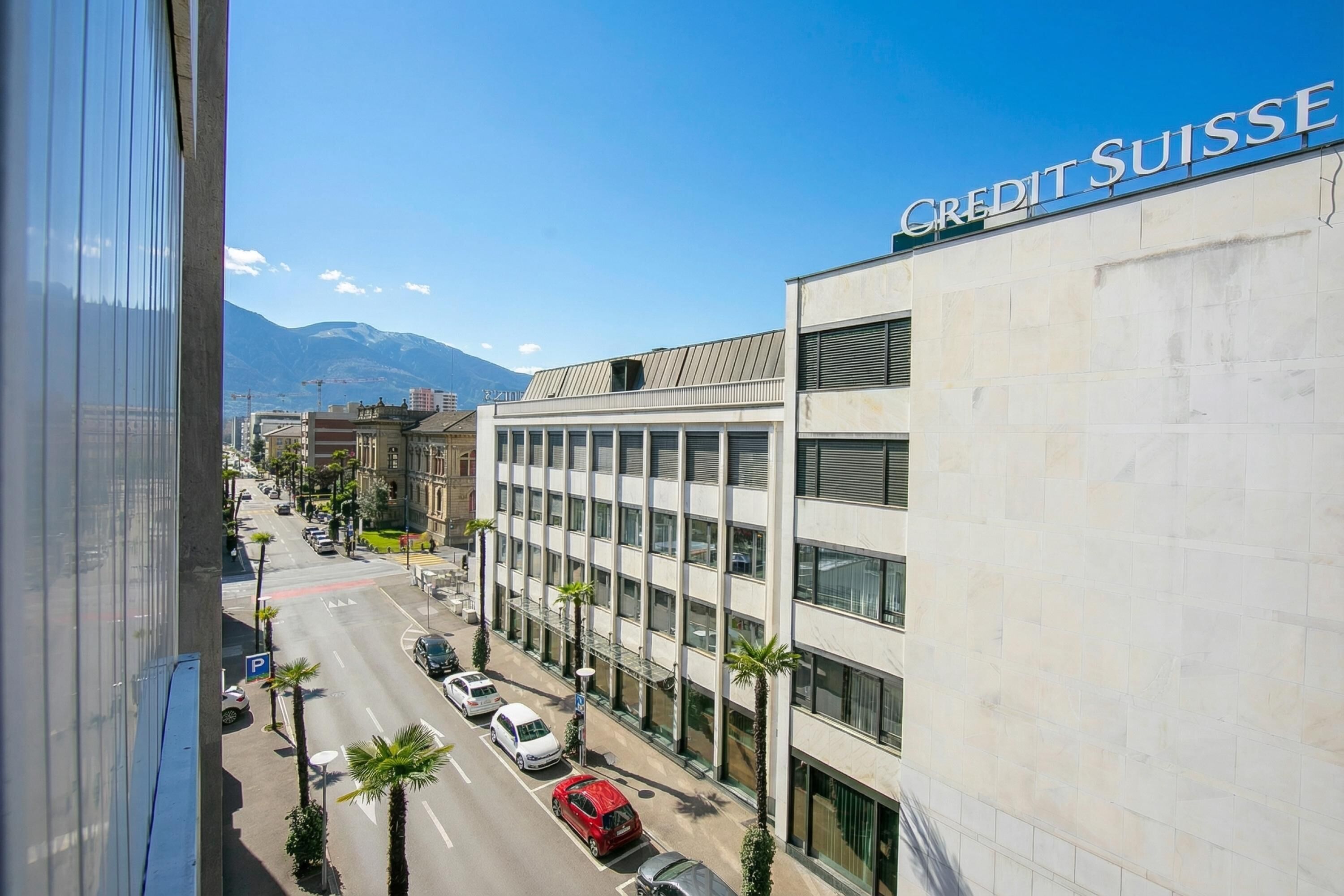 A modern building with a sign reading 'CREDIT SUISSE' on the top.