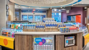 A beverage kiosk with a variety of drinks, a refrigerated section, and an ice cream machine. - Tru By Hilton Indianapolis Lawrence, In (Indianapolis)