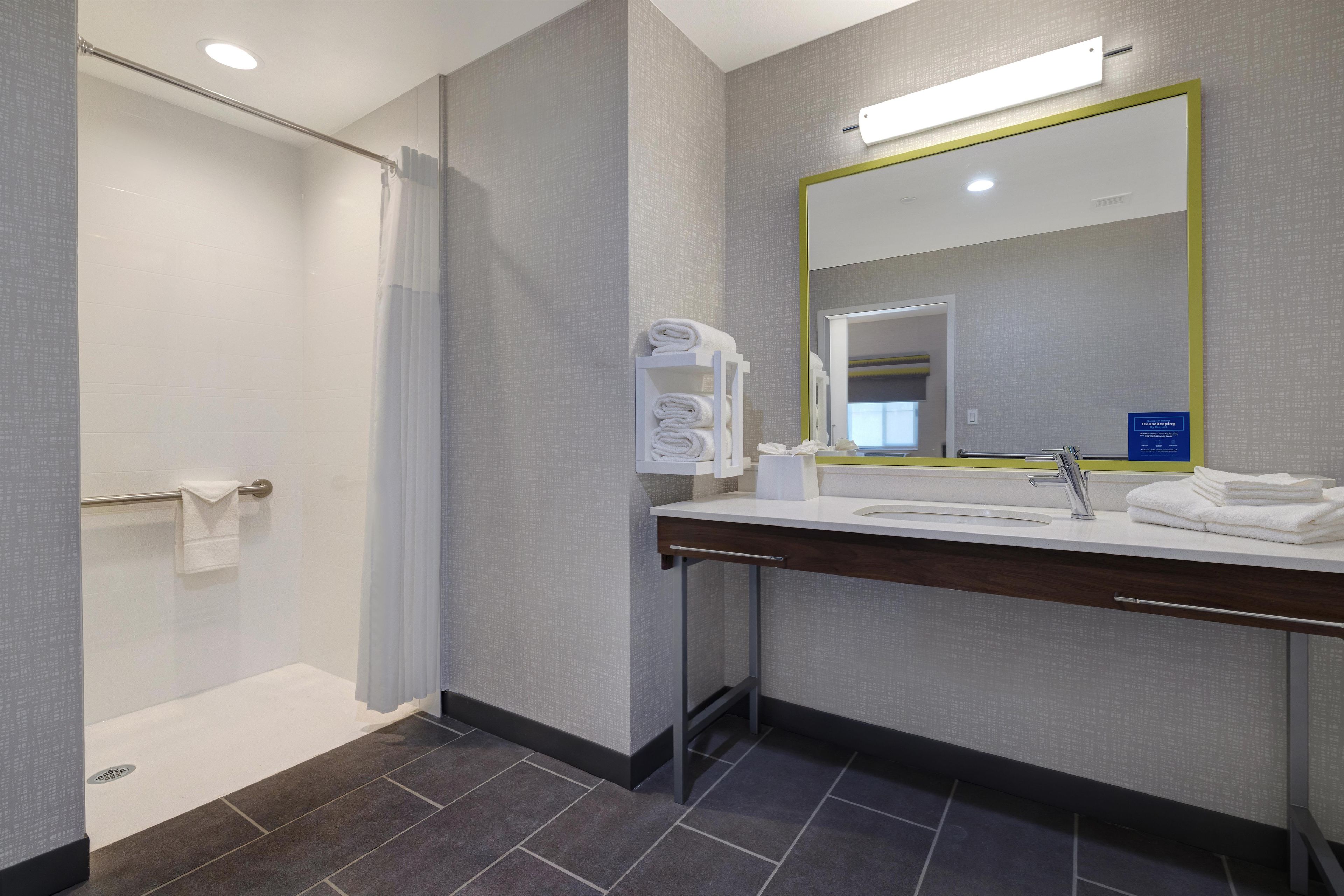 Un baño moderno con ducha, lavabo y espejo.