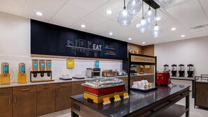A breakfast station with a coffee machine, toaster, and various food items. - Hampton Inn & Suites Marina (Marina)