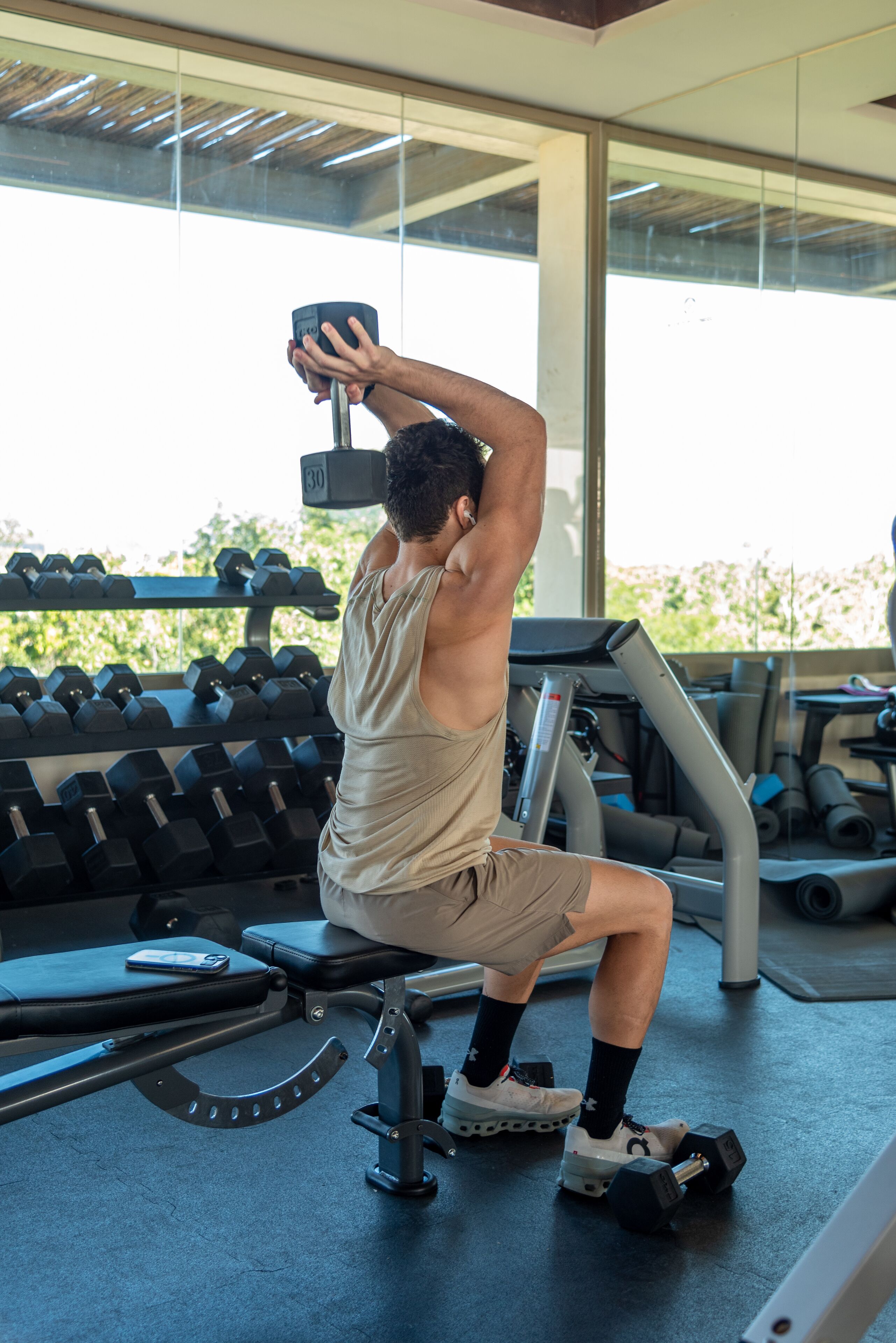 Un gimnasio con equipo de ejercicio, incluyendo mancuernas y una banca.