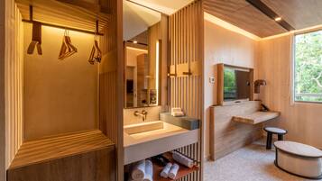 A modern bathroom with wooden paneling, a large mirror, a sink, and a toilet.