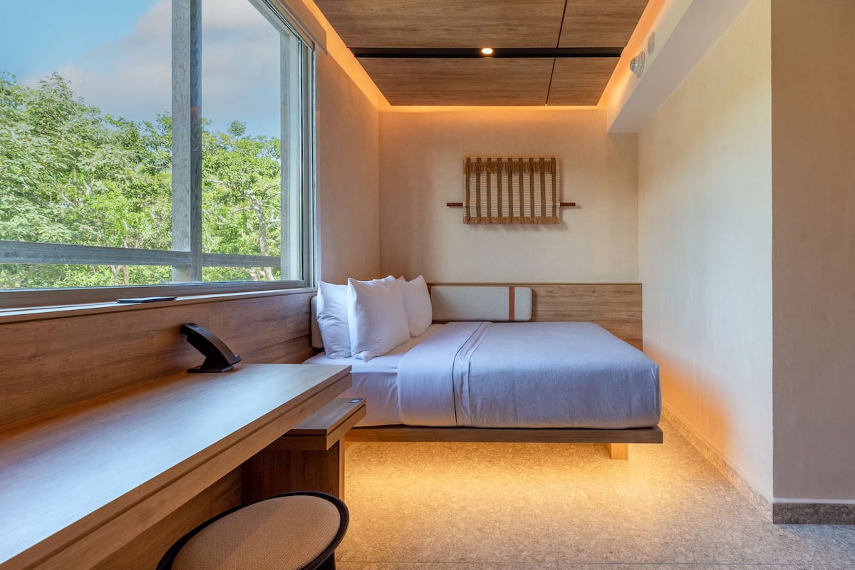 A modern bedroom with a bed, a desk, and a chair.