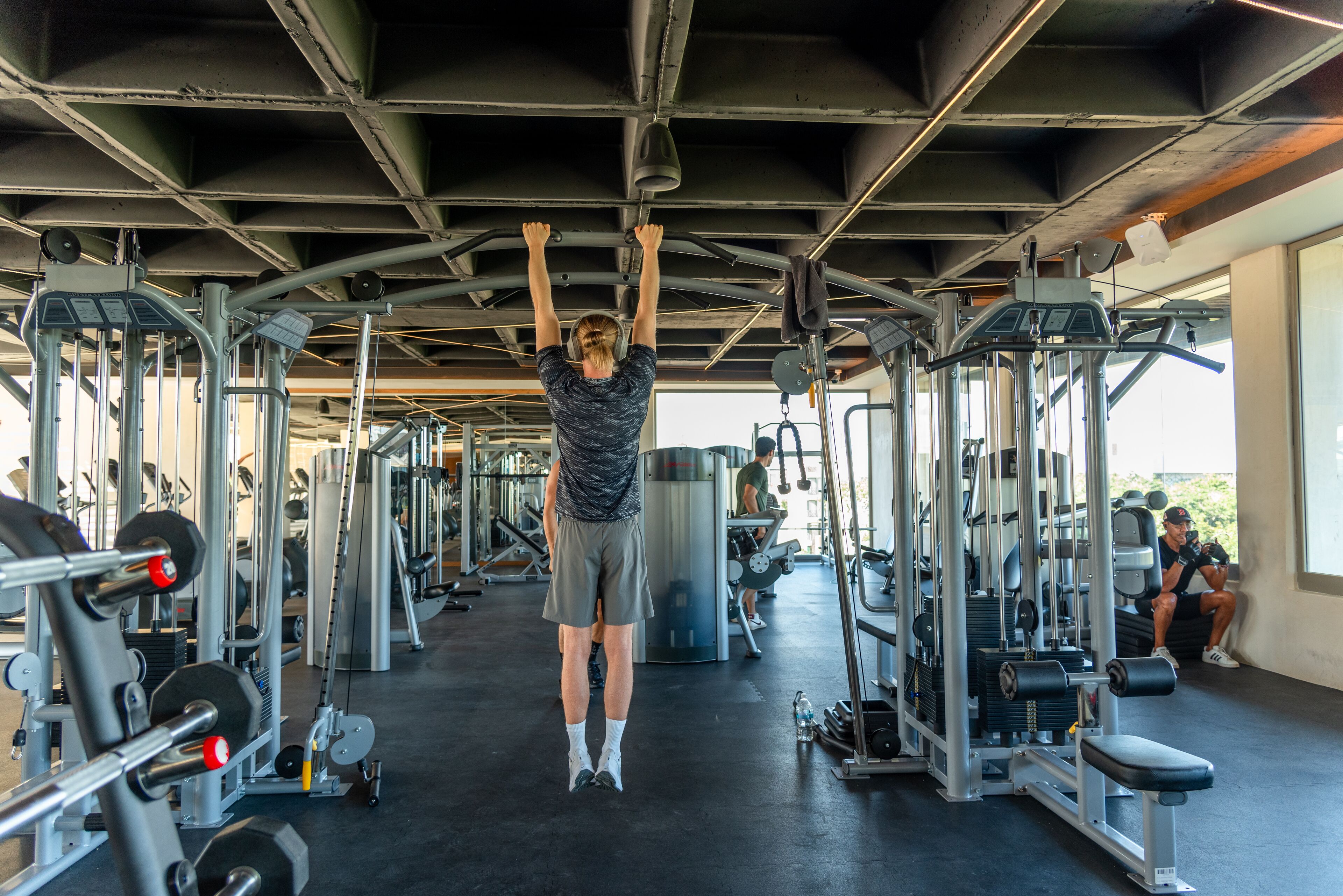 A gym with various exercise equipment, including a pull-up bar, weight machines, and benches.