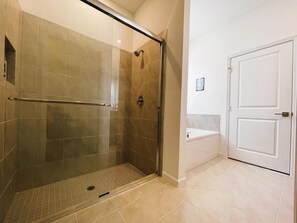 Design huis | Badkamer | Een bad/douchecombinatie, een haardroger, handdoeken, zeep