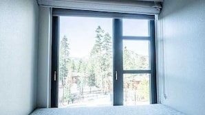 Une pièce dotée d’une grande fenêtre, d’une porte et d’un sol recouvert de moquette.