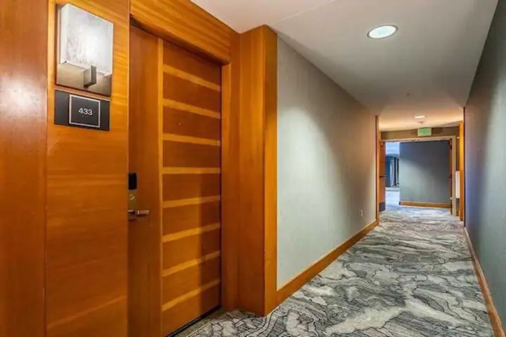 A hallway with a wooden door labeled "433" and a marble-patterned floor.