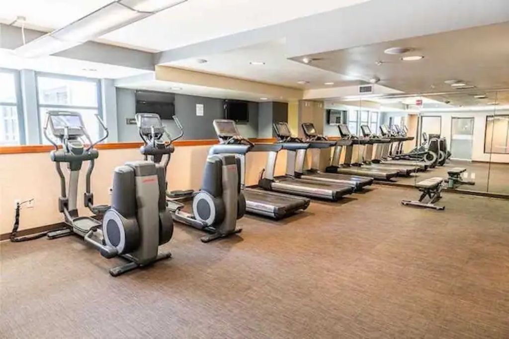 A gym with multiple treadmills and elliptical machines.