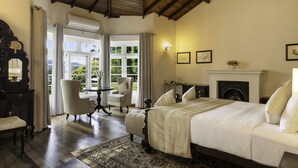 A bedroom with a large bed, a fireplace, and a view of the outdoors. - The Lavender House by Reveal (Pussellawa)
