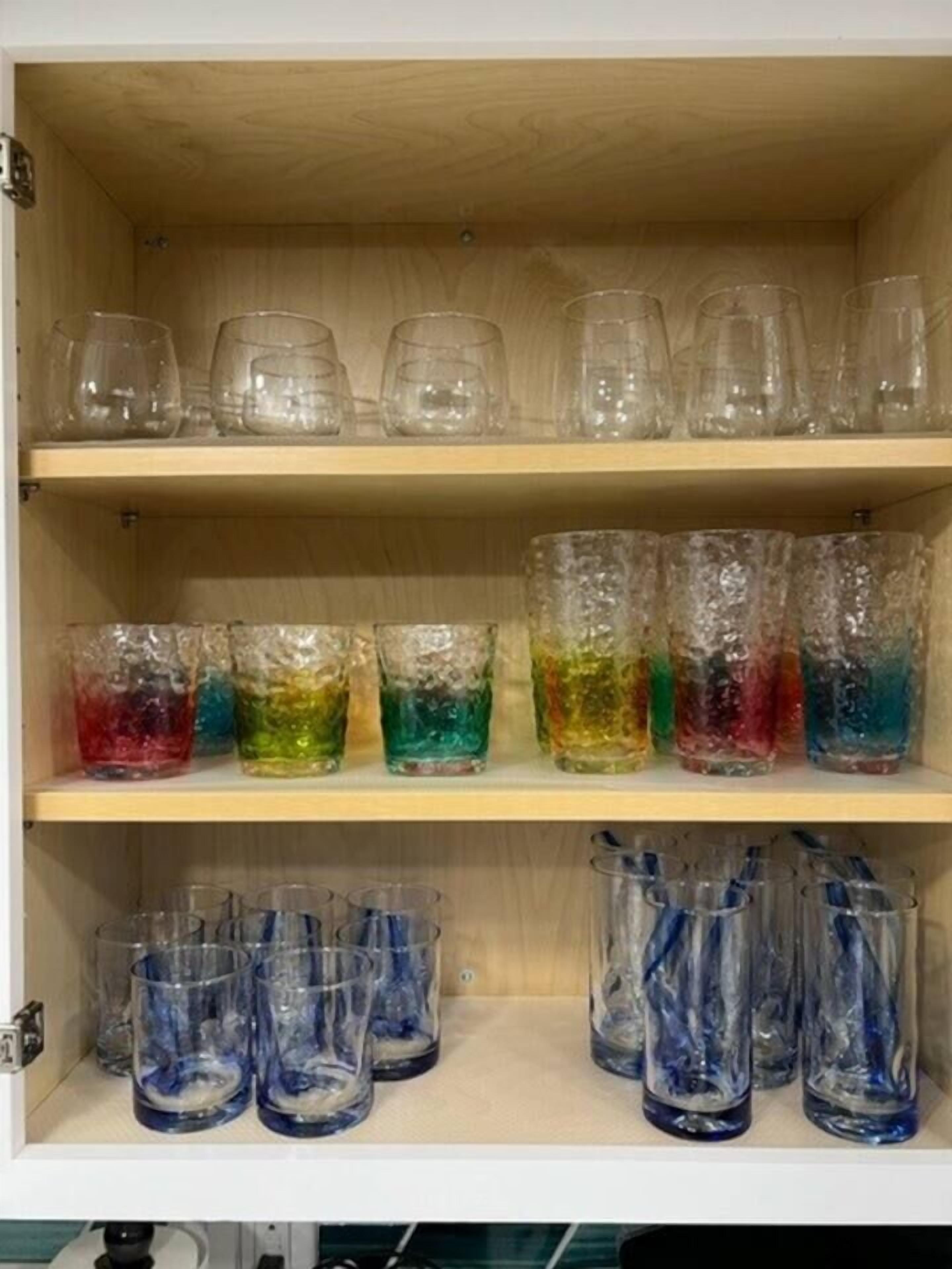 A wooden cabinet with shelves holding various glass containers.