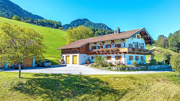 Un chalet à deux étages, doté d’un toit en pente, de balcons en bois et de fondations en pierre.