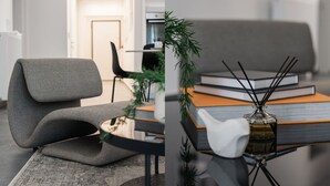 A modern living room with a grey sofa, a glass coffee table, and a bookshelf with books and a vase. - Stellar 3BR Apartment with Balcony (Paleo Faliro)