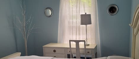 Un dormitorio con una cama, un escritorio y una silla.