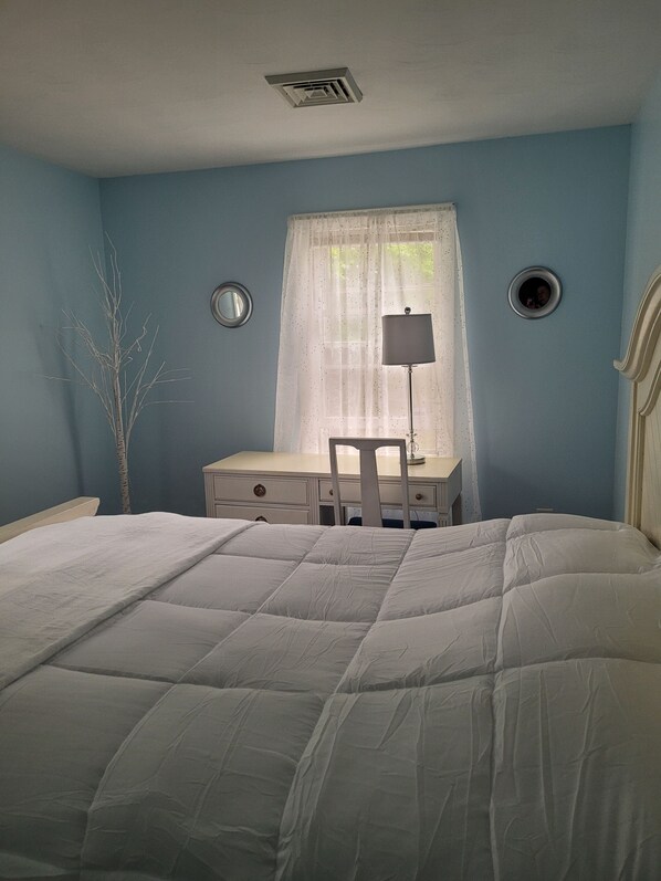 Un dormitorio con una cama, un escritorio y una silla.