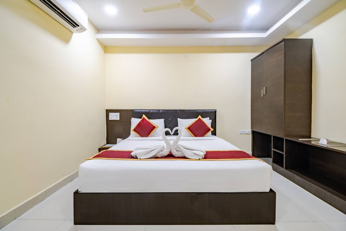 A hotel room with a bed, a wardrobe, and a ceiling fan.