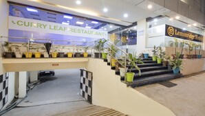 Un restaurant servant des plats à base de feuilles de curry, avec un escalier menant à un espace de stationnement.