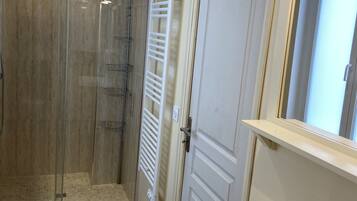 Een douche, handdoeken, zeep, toiletpapier