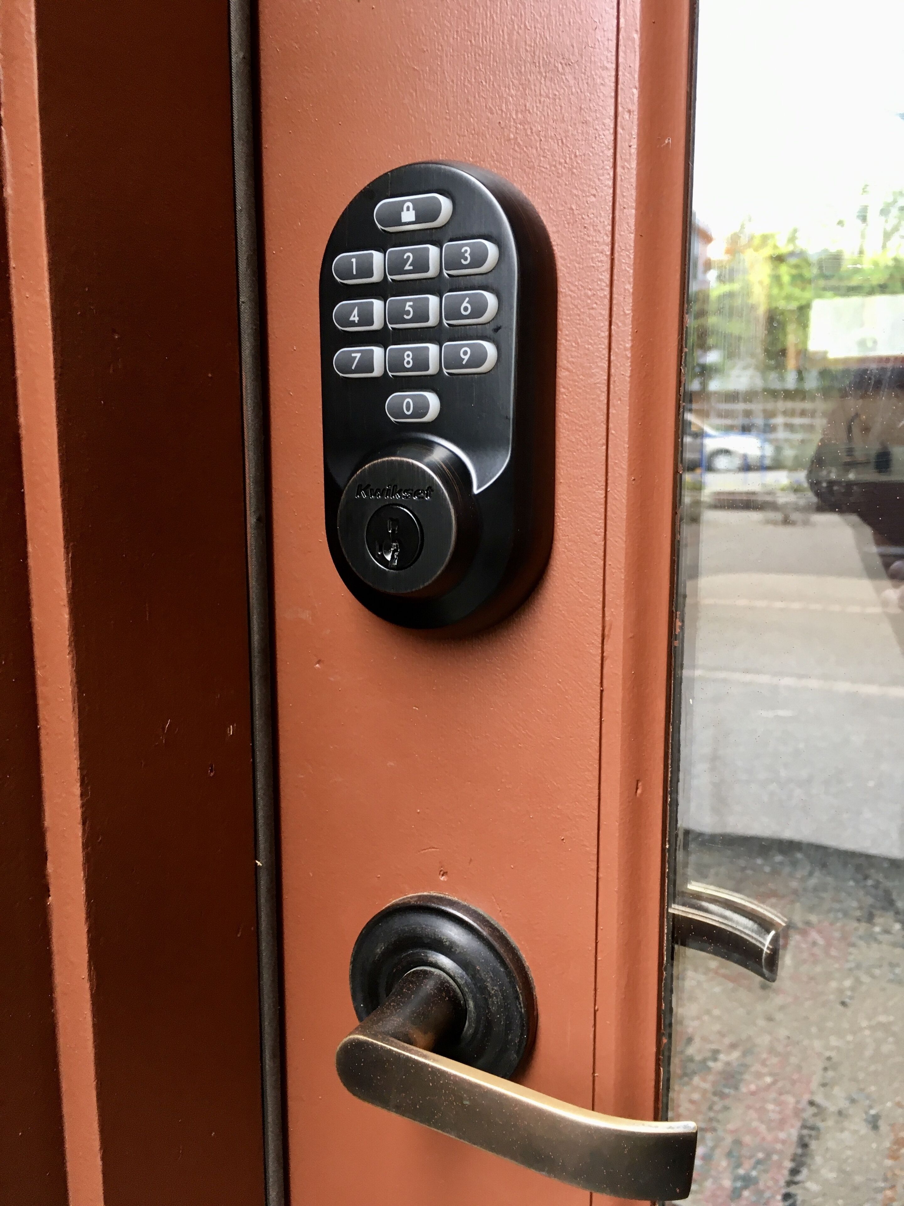A door with a keypad lock and a keyhole.