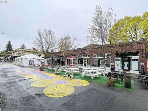 A courtyard with outdoor seating, a tent, and brick buildings with signage.