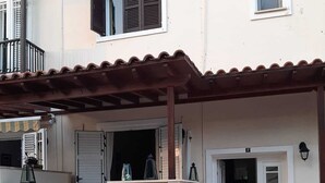 A two-story building with a covered patio area, a stone wall, and a door marked with the number 7. - Luxury Maisonette 250m from the beach. (Kato Paphos)