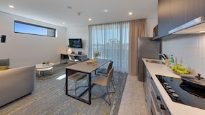 Una sala moderna con un sofá, una mesa de comedor y una zona de cocina con estufa y fregadero.
