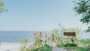 Un muelle de madera que conduce a una playa, con un cartel que dice 'The Famous Sandy Hook Pier'.