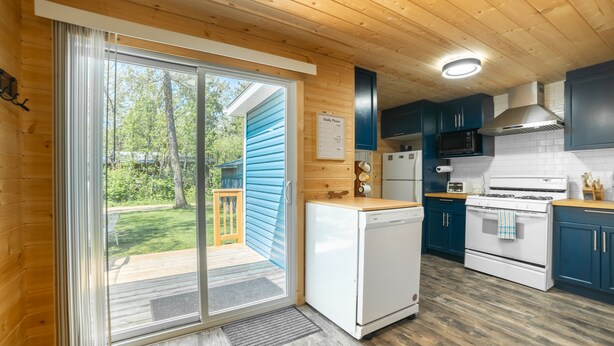 Una cocina moderna con armarios de madera, un refrigerador, un microondas y una estufa.