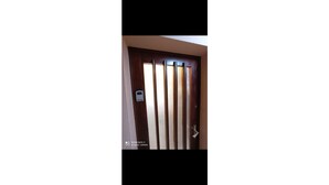 A door with vertical blinds partially drawn, a doorbell, and a sign indicating a room with a balcony. - Apartment close to the beach (Houlgate)